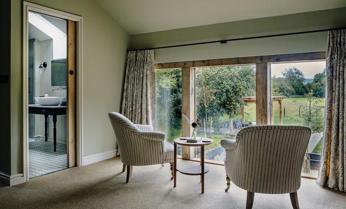 Lounge chairs looking out of glass doors toward the countryside